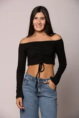 Top de algodón color marrón, con escote off-shoulder, mangas largas y detalle de frunce central con lazo ajustable.