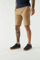 Bermuda tipo chino de gabardina con cierre de cremallera y botón, bolsillos laterales y traseros, y pasacintos en la cintura.