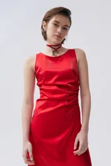 Vestido midi rojo de tafeta metalizada con frunces laterales, cuello bote, pliegues frontales y corte asimétrico.