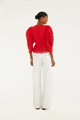 Pantalón blanco de sarga de pierna ancha con bordado floral de rosas rojas. Presenta un corte holgado y cintura alta.