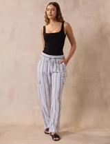 Pantalón cargo de lino a rayas verticales grises y blancas, marca Marissa Olivia. Pretina ancha elastizada con lazo de ajuste, bolsillos inclinados delanteros y bolsillos laterales con botón.