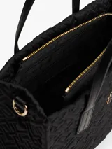 Cartera tipo tote de Tommy Hilfiger, color negro, confeccionada en nailon reciclado con diseño acolchado de monograma TH. Cuenta con dos asas superiores, correa ajustable extraíble, cierre de cremallera y logo metálico frontal.