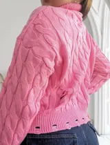 Sweater rosado de punto con cuello alto, mangas largas y diseño con roturas.