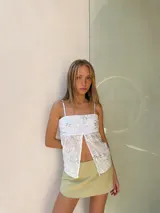 Top de tul color champagne con bordado de lentejuelas y diseño floral, tirantes finos, escote recto y abertura frontal pronunciada.