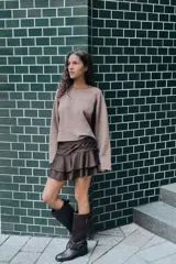 Falda pantalón de tiro medio con diseño de volantes en el ruedo y detalle de frunces en la cintura. Cierre lateral oculto.