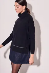 Sweater negro de cuello alto con tajos laterales y detalle de línea plateada en puños y ruedo.