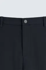 Pantalón de corte slim fit confeccionado en tejido elástico, con cintura elástica, cierre frontal con cremallera y botón, bolsillos laterales y bolsillos traseros de vivo.