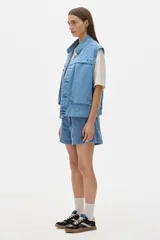 Chaleco de jean celeste con corte vintage y amplios bolsillos delanteros.