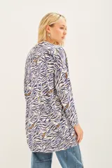 Saco tipo cardigan abierto de tejido liviano con estampado animal print en tonos azul y blanco. Presenta detalles bordados con lentejuelas a lo largo del diseño.