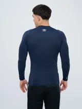 Remera térmica deportiva Umbro de manga larga y cuello redondo, en color azul marino, con logo de la marca estampado en el pecho.
