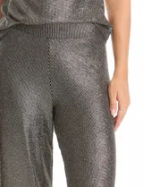Pantalón modelo palazzo de tiro alto con pretina ancha elastizada, confeccionado en tejido metalizado con textura acanalada.