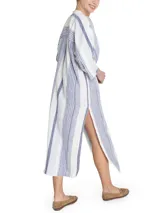 Túnica de corte amplio confeccionada en una mezcla de lino y algodón orgánico, con diseño a rayas verticales en tonos azul y blanco. Presenta escote en V con detalle desflecado, mangas tres cuartos y aberturas laterales en el ruedo.