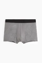 Pack de tres calzoncillos tipo trunk de punto elástico con costuras planas y cintura elástica. El set incluye un modelo en color gris melange y dos modelos en color negro.