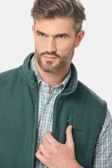 Chaleco de abrigo confeccionado en tejido polar color verde oscuro, con cuello alto, cierre frontal completo y bolsillo en el pecho con cierre. Presenta logo bordado en el frente.