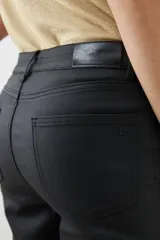 Pantalón de jean negro, tiro alto, corte cropped y botamanga acampanada.