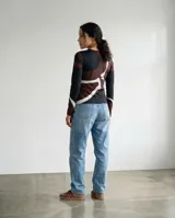Remera de manga larga con cuello redondo y diseño estampado con trazos orgánicos en tonos chocolate, negro y marfil.