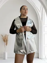 Chaleco largo plateado con textura simil piel de reptil, solapas y bolsillos delanteros.