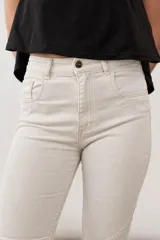 Jean oxford de tiro alto color beige, con bolsillos delanteros y traseros, costuras pespuntadas y cierre frontal con botón metálico.