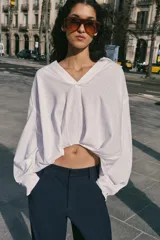 Camisa verde militar confeccionada en mezcla de lino, con cuello solapa, escote en pico, manga larga y diseño asimétrico con pliegues en la parte delantera.