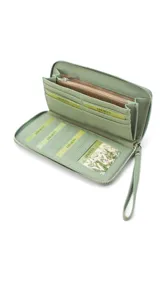 Billetera larga con cierre perimetral, confeccionada en material sintético con estampado botánico de flores silvestres sobre fondo claro. Cuenta con múltiples compartimentos internos para tarjetas, visor para documentos y un bolsillo interno con cierre. Incluye una correa de mano extraíble.