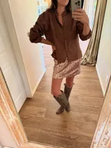 Minifalda de lentejuelas color rosado con acabado brillante, confeccionada en tela con spandex y elástico en la cintura para un ajuste cómodo.