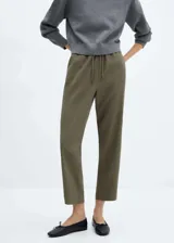 Pantalon de corte fluido y estilo jogger, color verde militar, con cintura elástica y lazo ajustable. Cuenta con dos bolsillos laterales y diseño de largo tobillero.