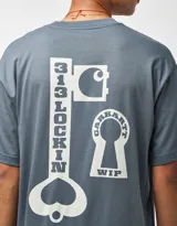 Remera de manga corta Carhartt WIP modelo S/S Locked, color gris oscuro, de corte holgado, con cuello redondo y estampado gráfico en el pecho en forma de cerradura con el nombre de la marca.