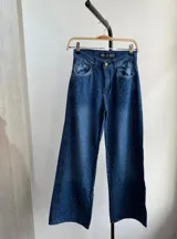 Pantalón de jean azul con corte recto y tachas plateadas.