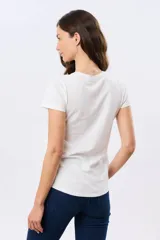 Remera blanca de manga corta y cuello redondo, confeccionada en algodón, con delicado bordado floral localizado en el hombro.