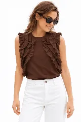 Remera sin mangas blanca con escote a la base y volados aplicados en los hombros.