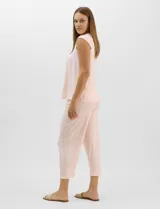 Pijama compuesto por remera sin mangas con escote redondo, botones frontales y detalle de puntilla, acompañado de un pantalón capri con cintura elástica. Presenta un estampado floral en tonos rosados sobre base gris.