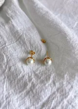 Par de aros dorados con perlas blancas.