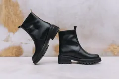 Botas de cuero marrón con suela track de goma negra, cierre lateral en color rojo y detalle de tira trasera al tono.