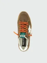 Zapatillas Golden Goose modelo Ball Star, confeccionadas en gamuza marrón con efecto desgastado. Presentan una estrella lateral blanca, cordones naranjas, detalle plateado en el talón y suela de goma con acabado envejecido.