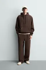 Sudadera con capucha de corte relajado, confeccionada en tejido de algodón con interior perchado. Presenta mangas largas, bolsillo frontal tipo canguro y terminaciones en rib.