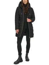 Campera larga tipo puffer de Tommy Hilfiger, color negro, con diseño acolchado horizontal, capucha con cordones ajustables y cierre frontal de cremallera. Cuenta con bolsillos laterales con cierre y logo distintivo de la marca.