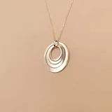 Collar de plata 925 compuesto por una cadena fina y un dije colgante formado por tres aros concéntricos de diferentes tamaños.