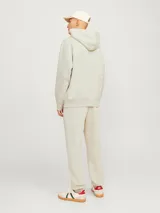 Hoodie color crema de manga larga con capucha, bolsillo canguro y calce holgado. Confeccionado con tejido de algodón y poliéster reciclado.