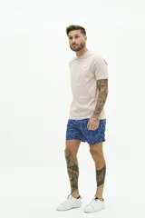 Short de baño con estampado floral en tonos azules, cintura elástica con cordón ajustable, bolsillos laterales y bolsillo trasero.