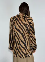 Blusa azul con estampado de cebra en negro, escote en V y mangas largas abullonadas.