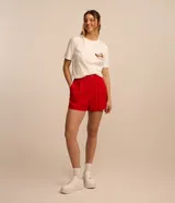 Short holgado de viscosa texturizada color rojo, con cintura estilo sastrería al frente y elástico en la parte trasera. Cuenta con bolsillos laterales y cierre frontal con botón y cremallera.