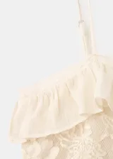 Vestido corto color crudo, con tirantes finos, detalles de encaje y volados en el pecho.
