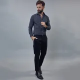 Pantalón de gabardina color azul marino, de corte ajustado y tiro medio, con cierre y botón frontal.