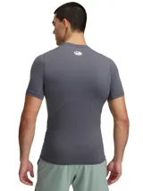 Remera de compresión Under Armour de manga corta, color gris, con cuello redondo y logo de la marca estampado en el pecho. Confeccionada en tejido técnico HeatGear con paneles de malla para mayor ventilación.