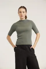 Blusa de punto acanalado color negro, con cuello alto y mangas cortas.