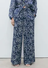Pantalon de corte recto y tiro medio, confeccionado en tejido de algodón con estampado paisley. Presenta cintura con elástico y bolsillos laterales.