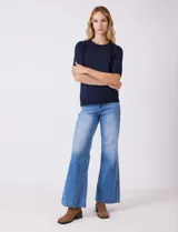 Buzo de tejido fino en color azul marino, con cuello redondo y mangas cortas con puños acanalados.