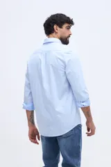 Camisa de manga larga color rosado, con cuello abotonado, cierre frontal de botones y un bolsillo ojal en el pecho.