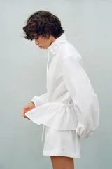 Chaqueta de nylon color blanco, con cuello subido y cordón ajustable, manga larga con puños elásticos y cordón ajustable en la cintura. Cierre frontal con cremallera oculta.