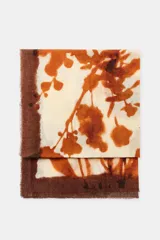 Pañuelo rectangular de gran tamaño confeccionado en mezcla de lana, con estampado botánico en tonos marrones sobre fondo crema y bordes deshilachados.